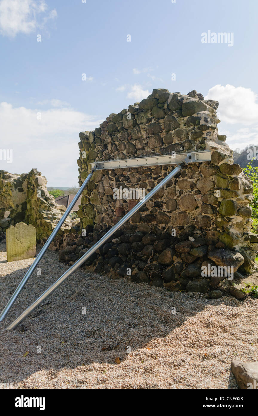 Mur d'une ruine de l'église, instable et nécessitant un soutien. Banque D'Images