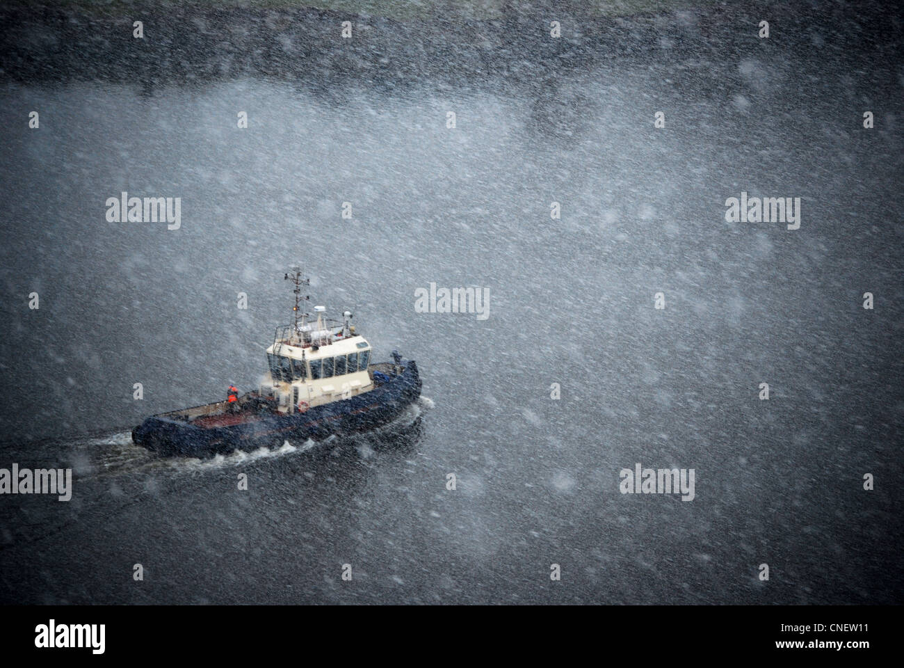 Tug Boat pris dans un blizzard sur la rivière Clyde, en Écosse. Banque D'Images