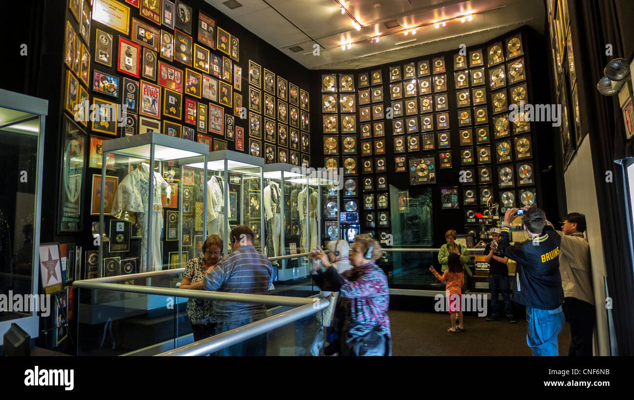 Les visiteurs du musée à l'Elvis Presley Graceland avec des disques d'or et de costumes de scène Banque D'Images