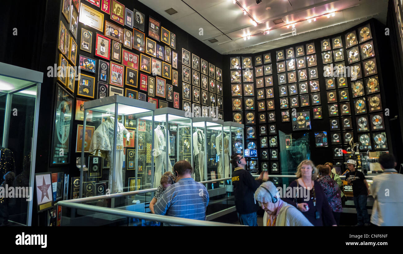 Les visiteurs du musée à l'Elvis Presley Graceland avec des disques d'or et de costumes de scène Banque D'Images