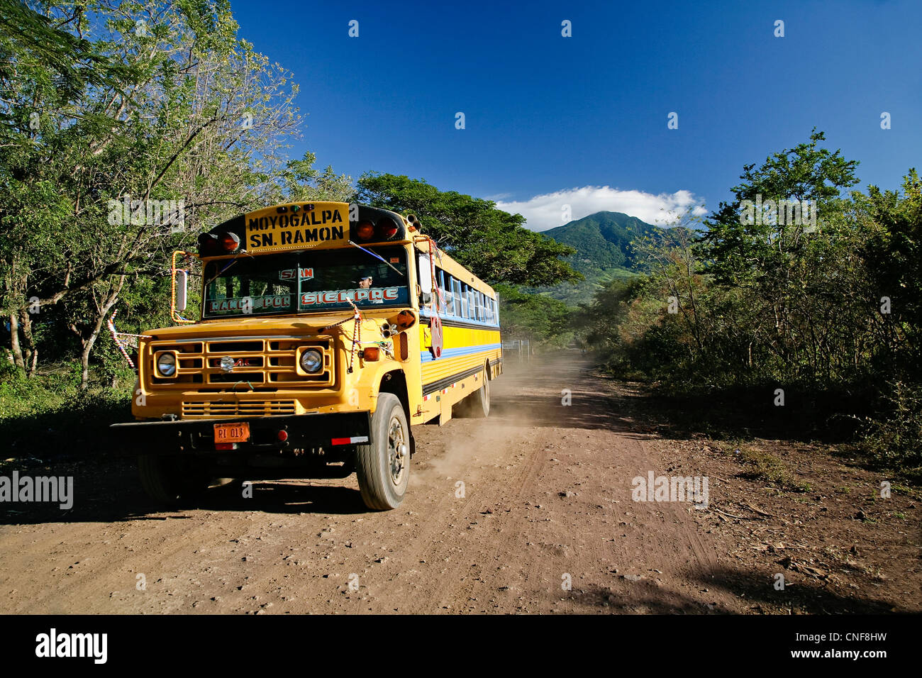 Nicaragua Isla Ometepe sur le Lac Nicaragua bus poulet en déplacement sur route de gravier avec madera volcan en arrière-plan l'île Ometepe Banque D'Images
