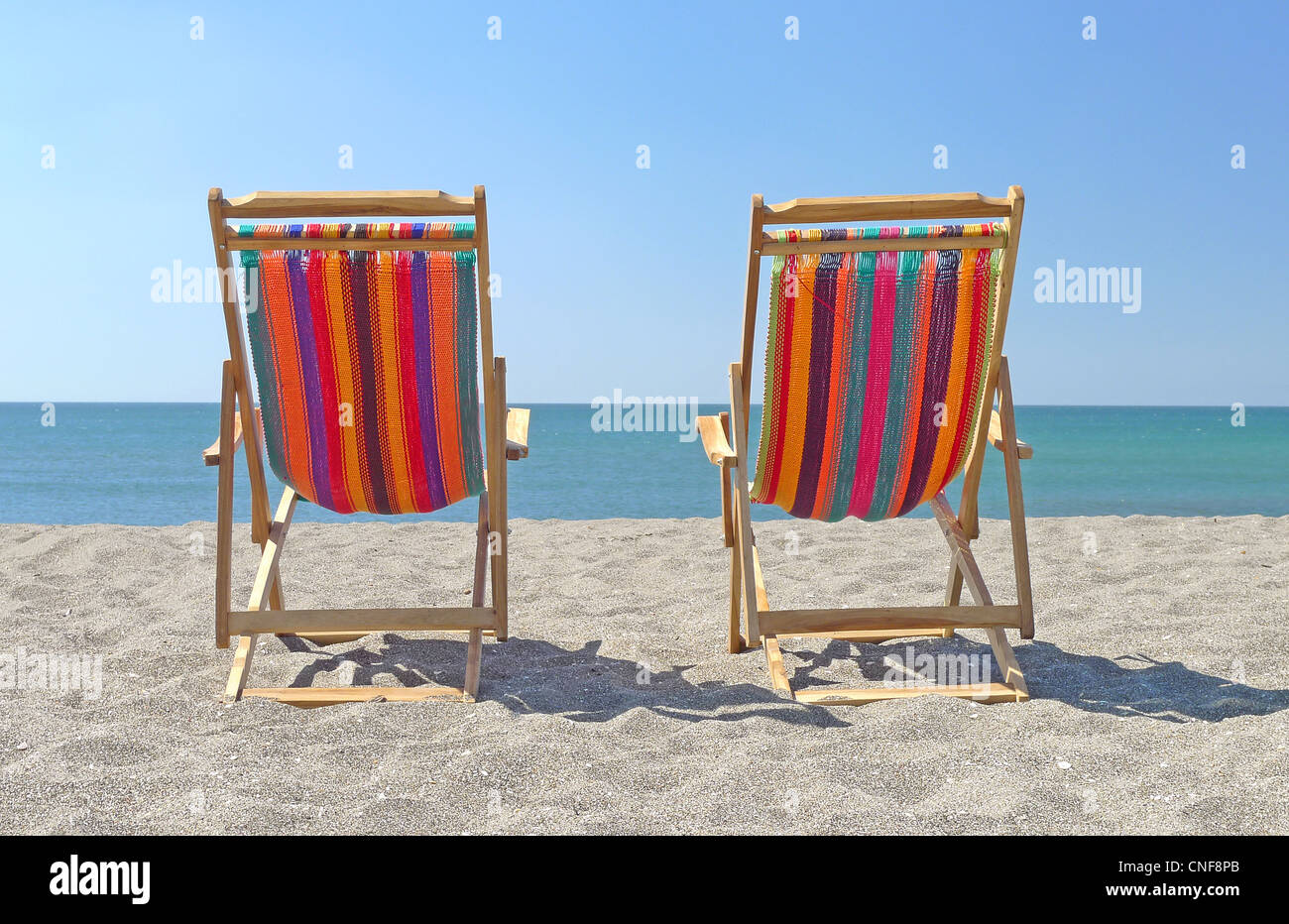 Deux chaises sur la plage de sable de l'été ensoleillé jour ciel bleu clair rivages océaniques voir copy space Banque D'Images