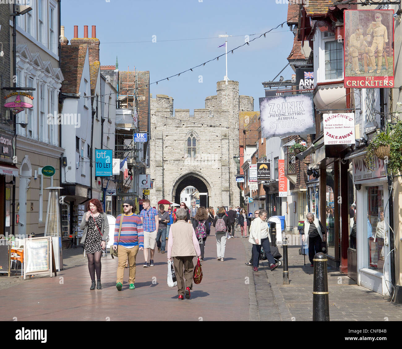 Canterbury UK High Street avec les consommateurs et les touristes profitant d'une journée ensoleillée. La célèbre Westgate Towers sont à l'arrière-plan. Banque D'Images