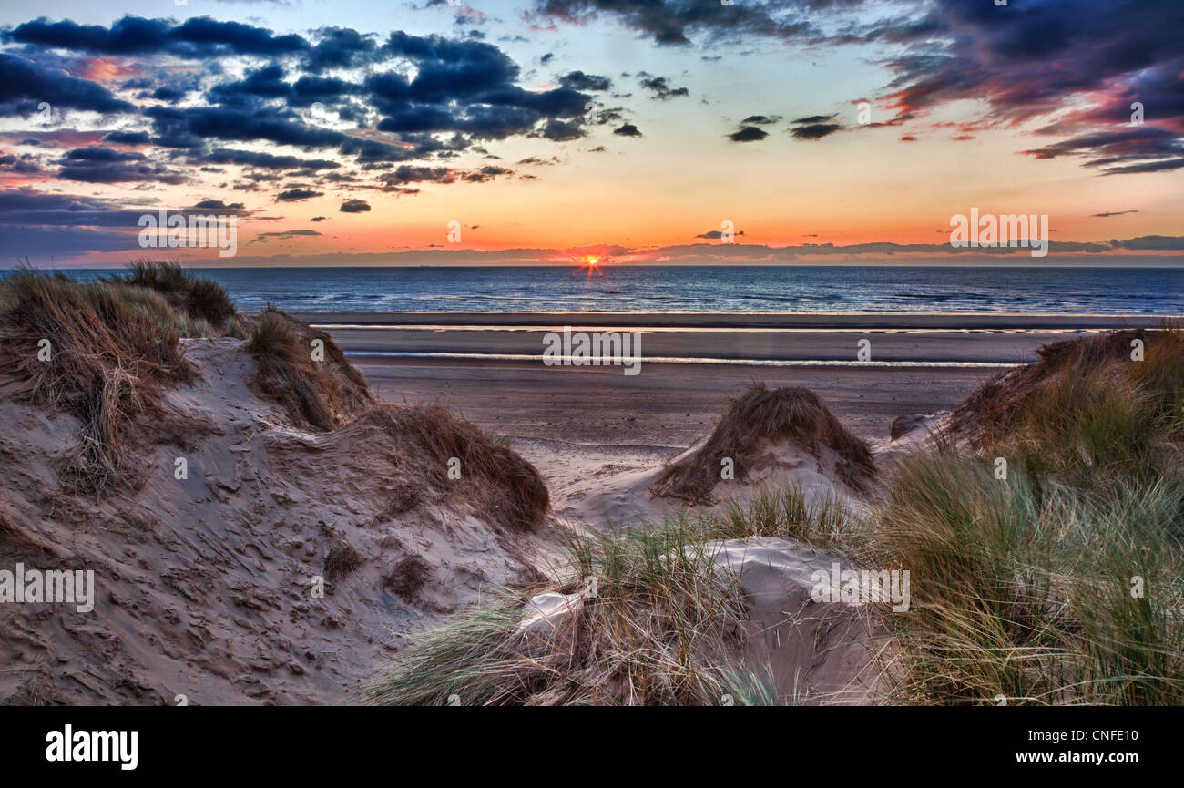Coucher de soleil sur la plage à Formby dans le Lancashire, Angleterre à travers les dunes de sable Banque D'Images