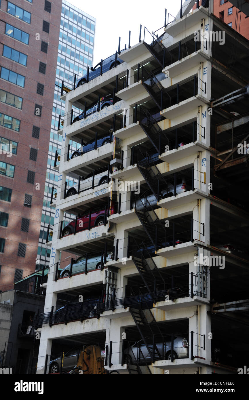 Portrait urbain ascenseur garage à étages, de nombreuses voitures en stationnement, Fulton Street at Cliff Street, Lower Manhattan, New York Banque D'Images