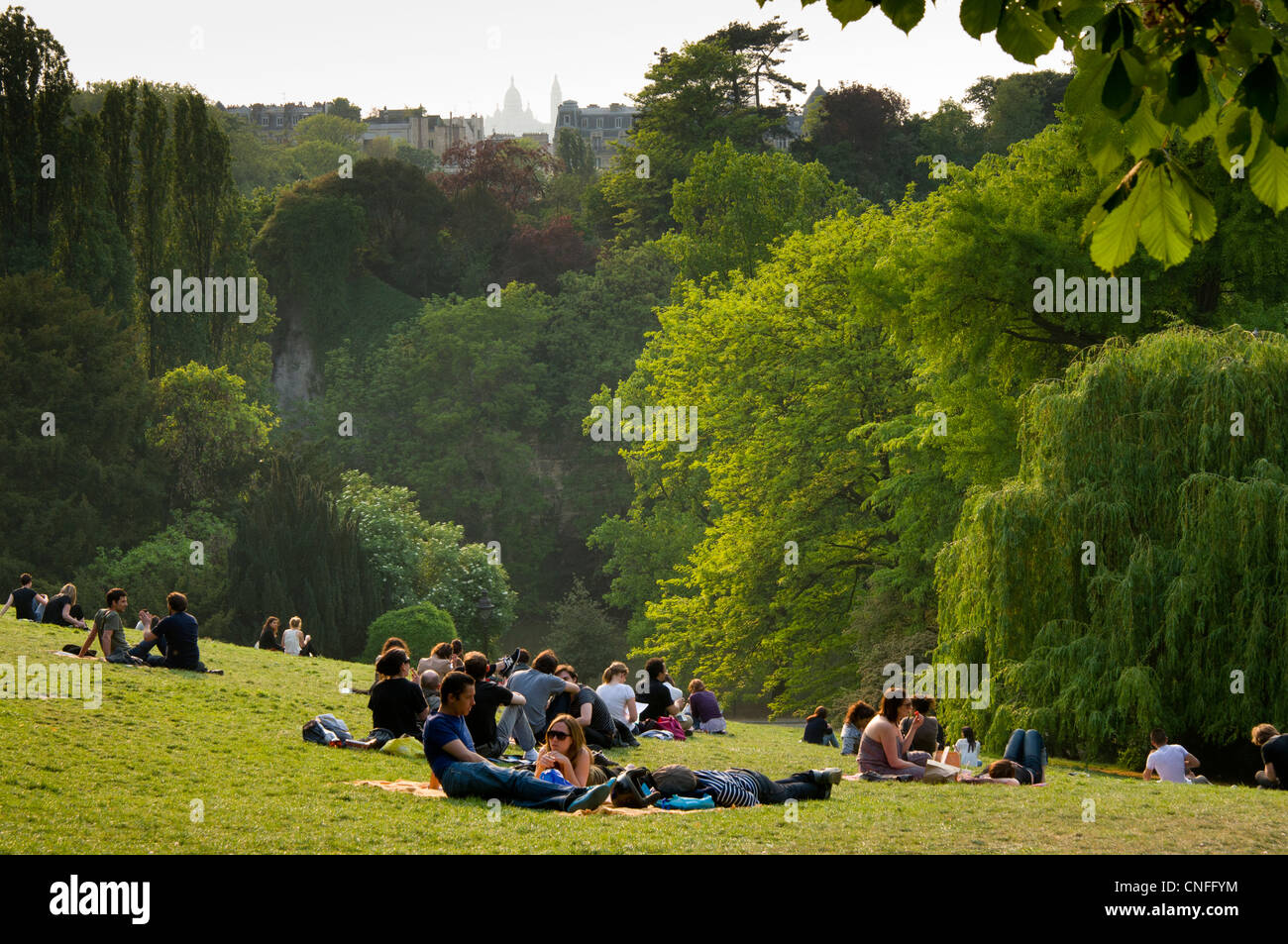 Les gens se détendre sur l'herbe et colline verte de Parc des Buttes-Chaumont, Paris, France Banque D'Images