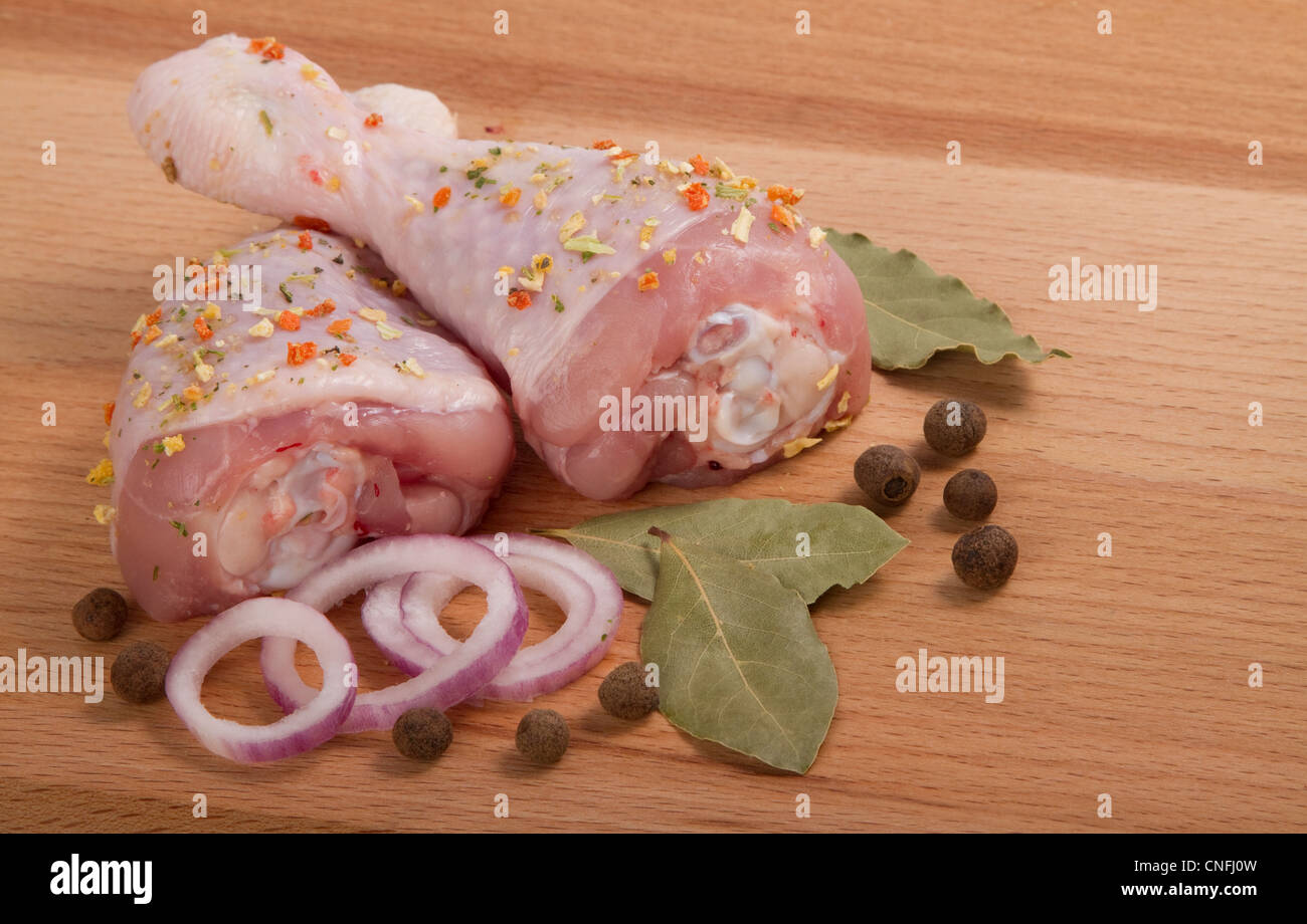 La viande de poulet crue avec les herbes, les oignons et poivrons, sur une planche à découper Banque D'Images