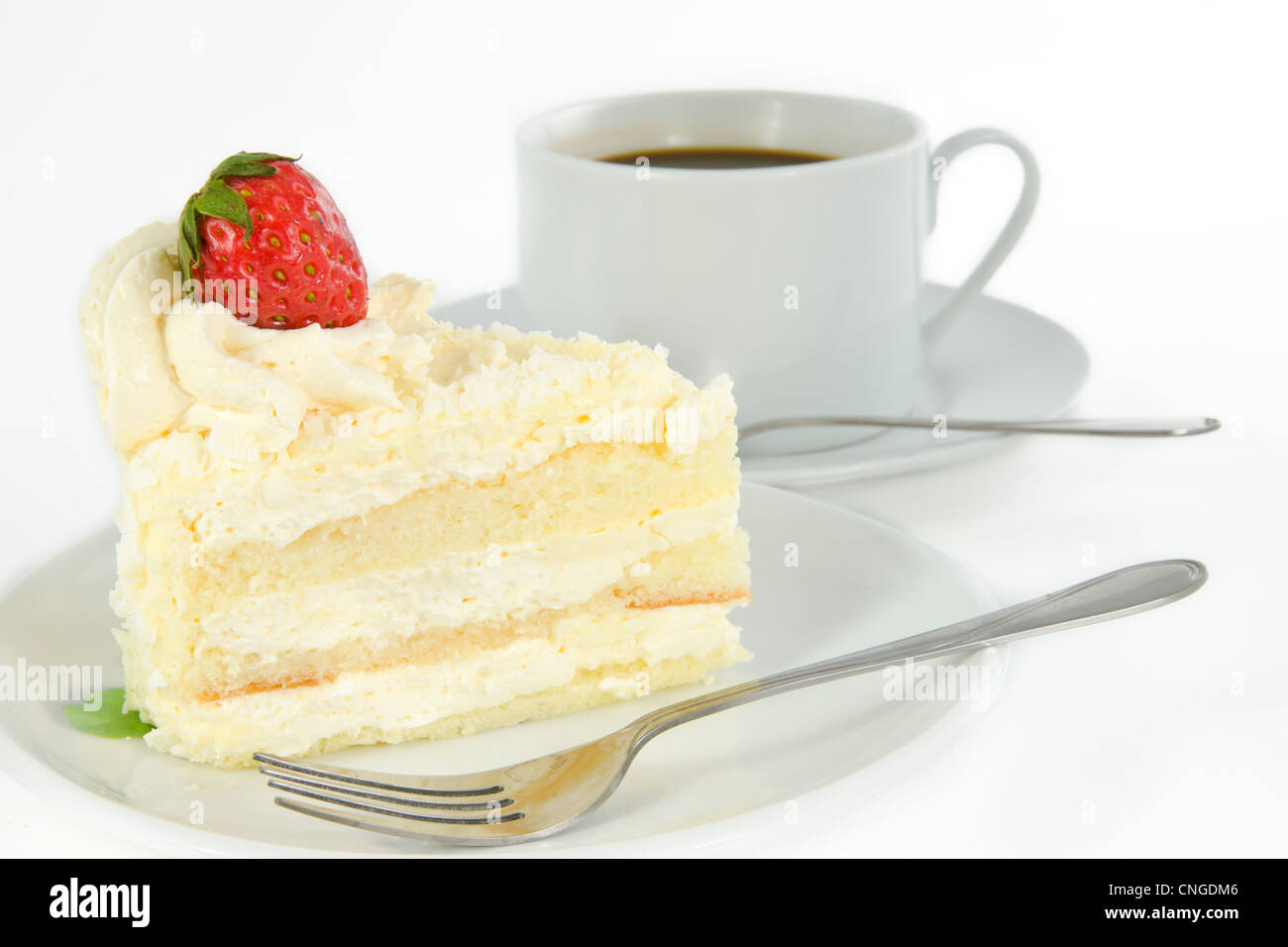 Délicieux gâteau vanille fraise avec décorer sur le dessus et une tasse de café Banque D'Images