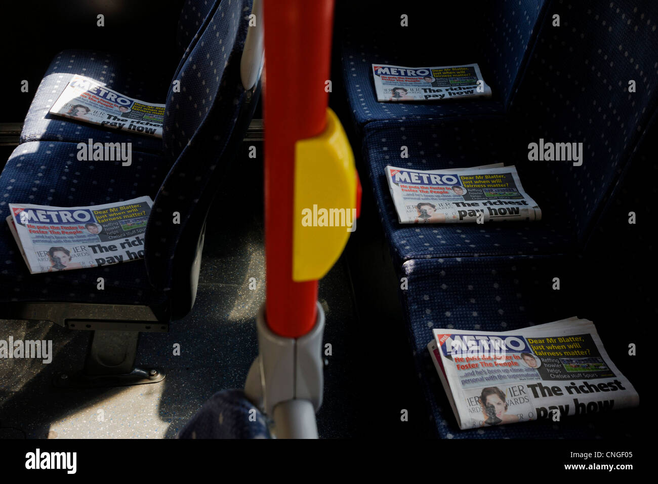 Des copies des articles de journal journal Métro soigneusement placées sur le pont supérieur des sièges sur un bus de Londres. Banque D'Images