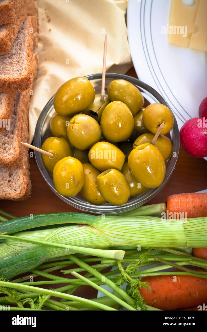 Close up de table avec des olives vertes et des légumes frais. Banque D'Images