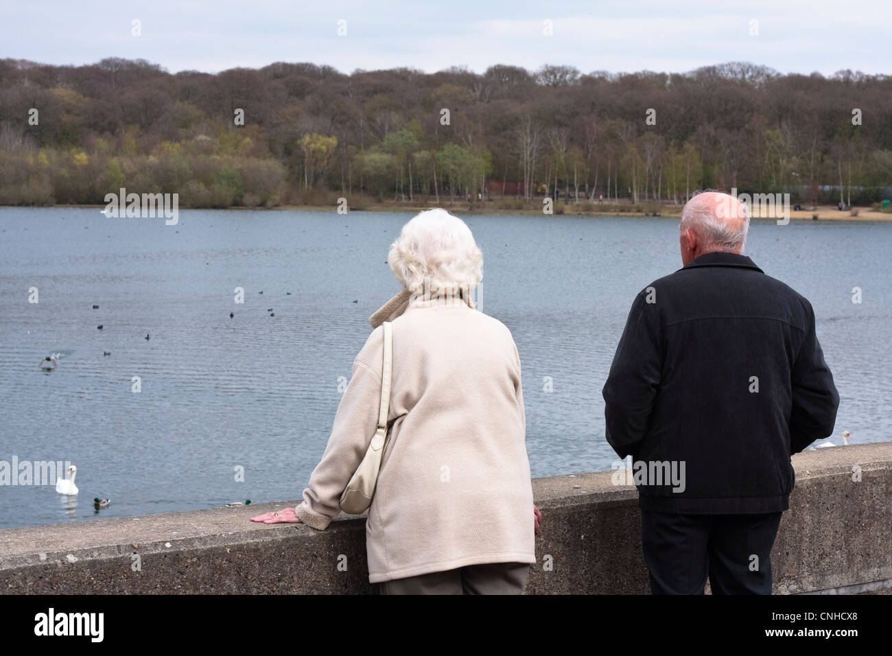Un couple de personnes âgées donnent sur le lac à Ruislip Lido, au Royaume-Uni. Banque D'Images