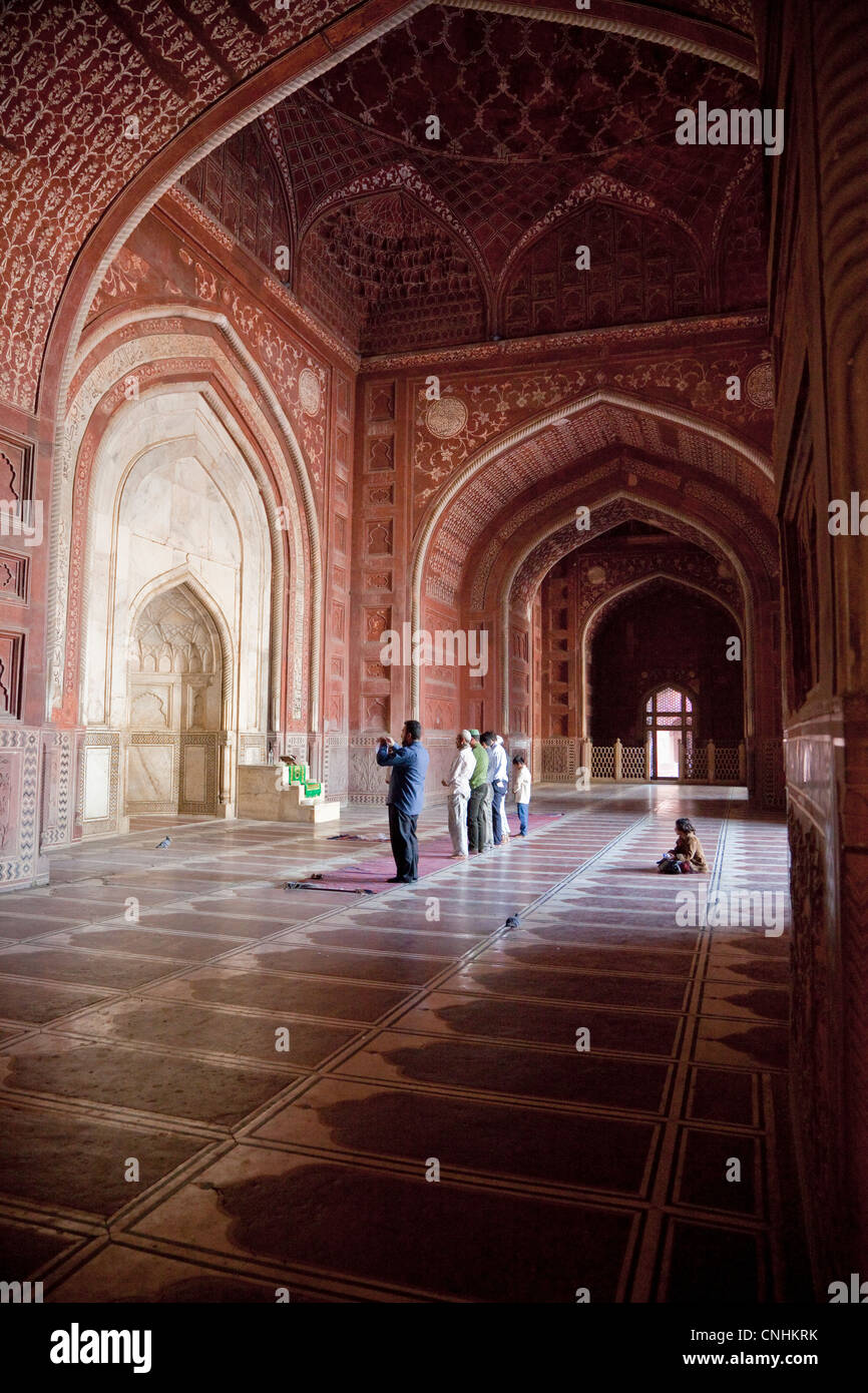 Agra, Inde. Mosquée du Taj Mahal. Fidèles à la mi-journée de prière. Petite fille en arrière. Banque D'Images