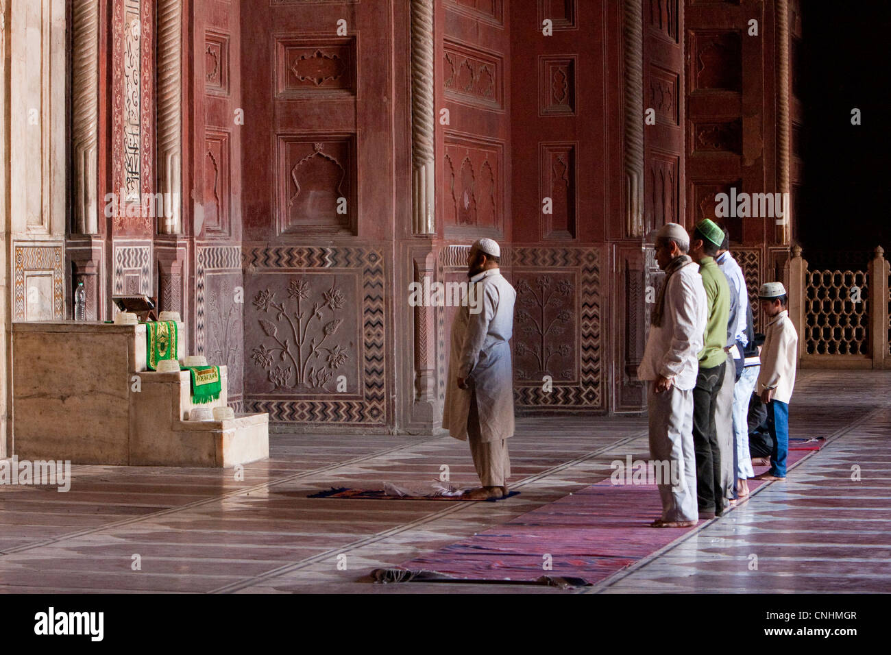 Agra, Inde. Mosquée du Taj Mahal. Les hommes priant, l'Imam dans la prière avant de bord. Banque D'Images