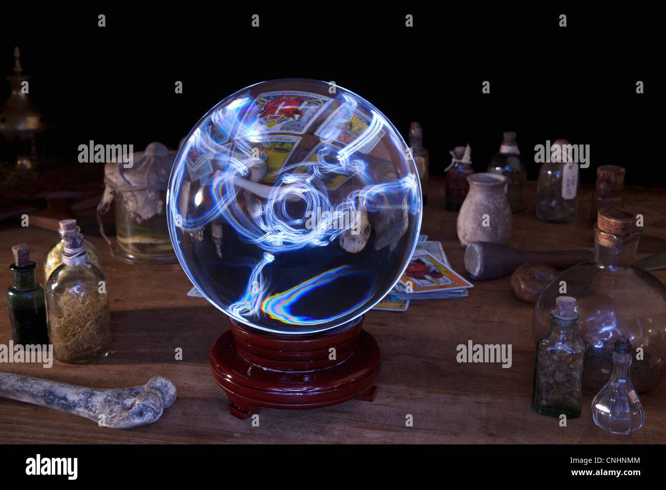 Une boule de cristal au milieu d'bouteilles et cartes de tarot Banque D'Images