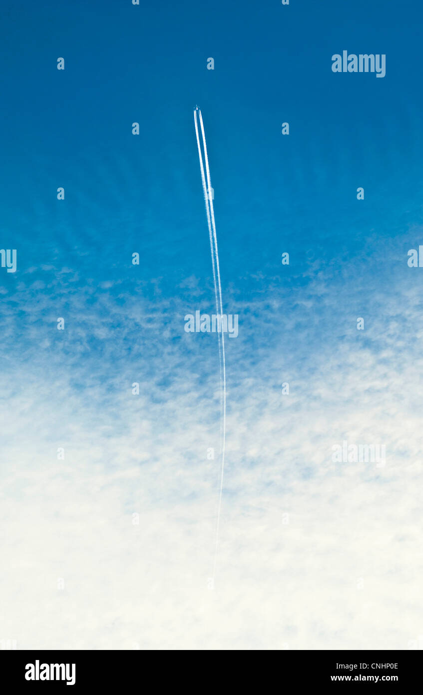 Un avion avec une traînée de vapeur Banque D'Images