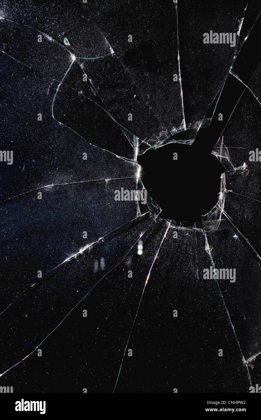 Une fenêtre avec un trou à travers le verre brisé, nuit Banque D'Images