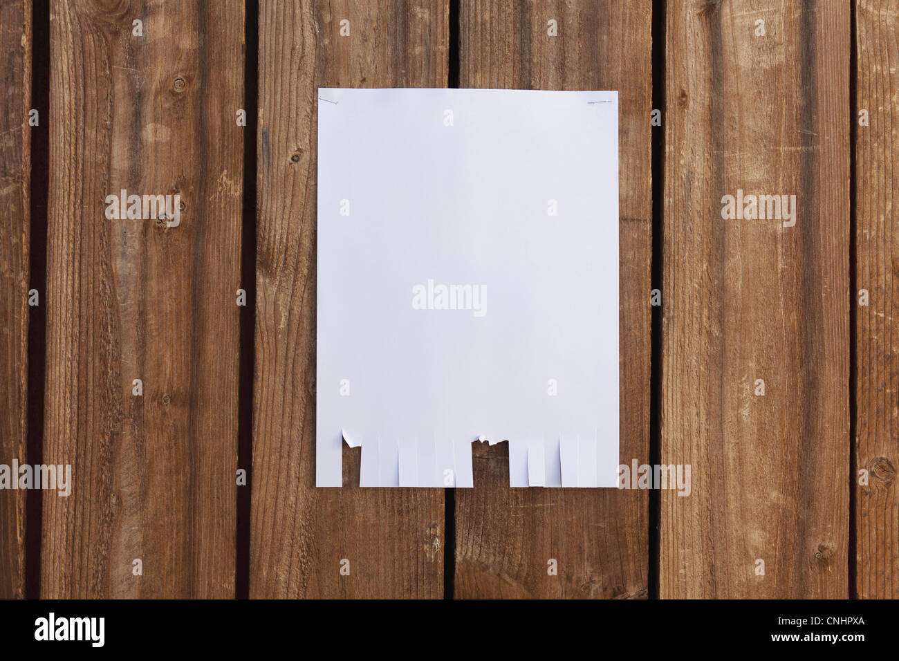 Un flyer en blanc accroché à une clôture en bois Banque D'Images