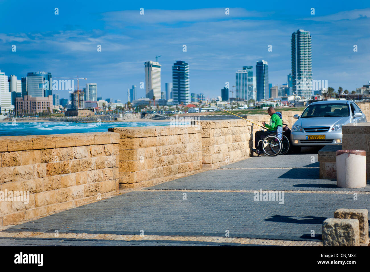 Moyen Orient Israël Tel Aviv Mer Méditerranée plage de jour ensoleillé - homme handicapé en fauteuil roulant : pêche à la ligne Banque D'Images