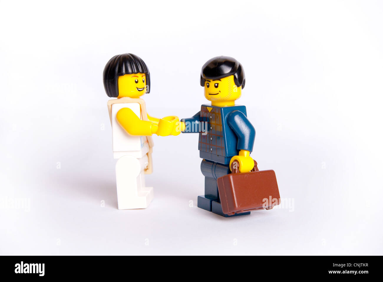 Deux Lego jouet business people shaking hands on high key background Banque D'Images