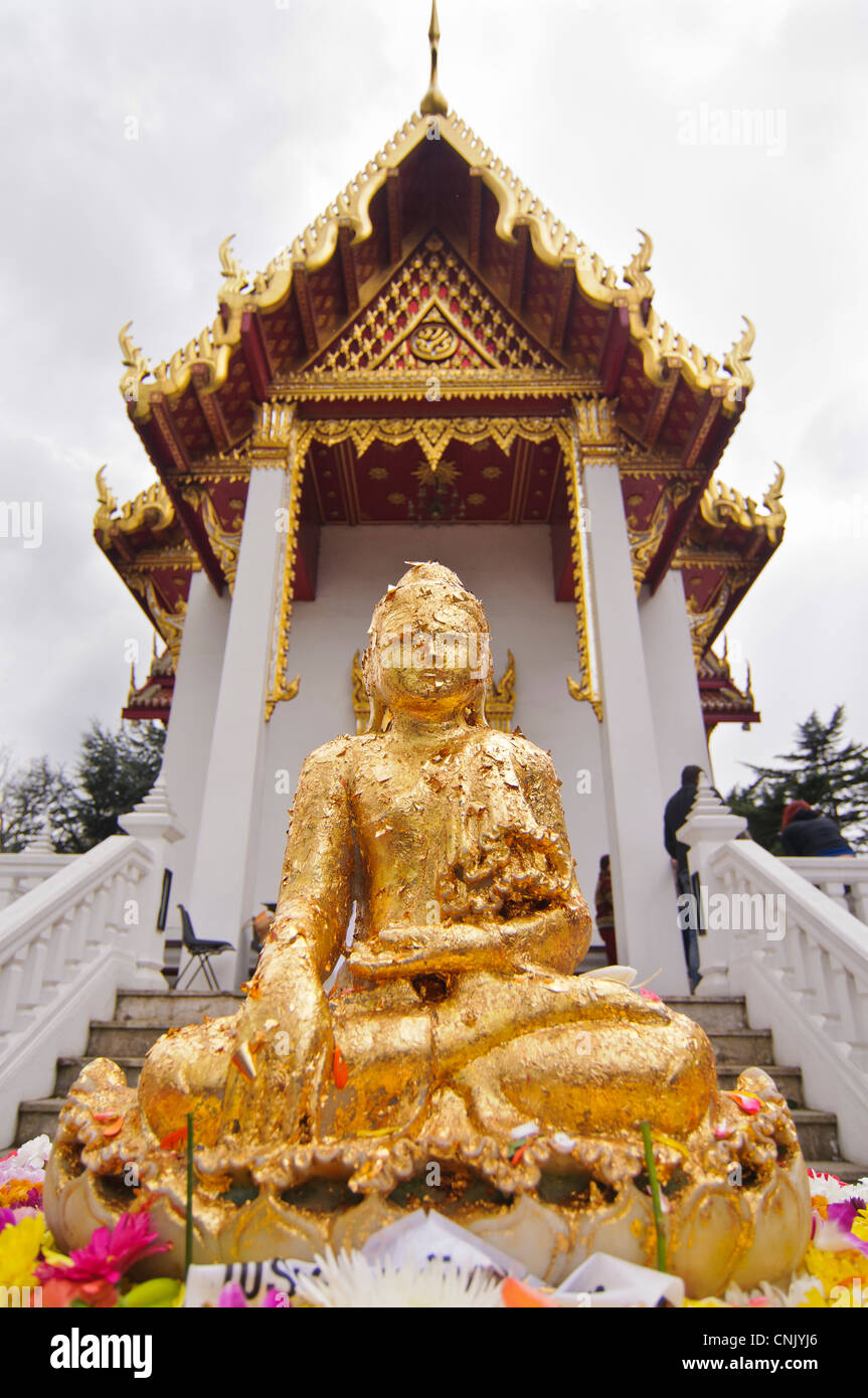 À la Thai temple de Wat Buddhapadipa pour célébrer Songkran, Nouvel An thaï, Des offrandes sont faites à une statue de Bouddha Banque D'Images