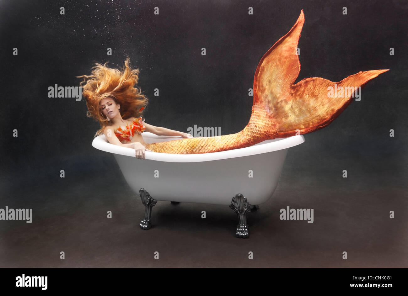 Jeune sirène se prélasser sous l'eau dans sa baignoire Victoria et Albert Banque D'Images