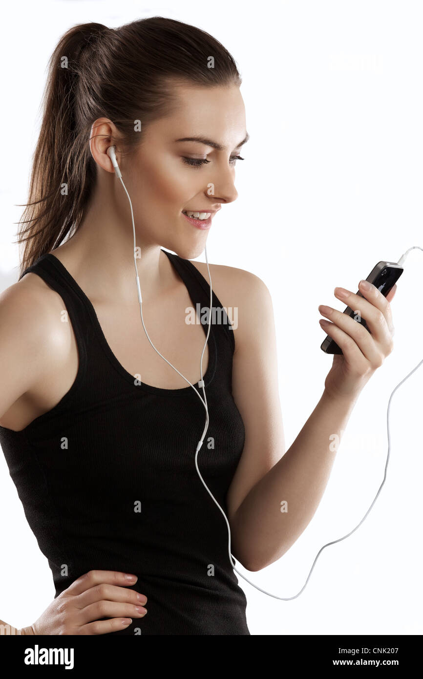 Belle jeune femme à la surveiller calorie après l'exercice avec son iPhone 4 Banque D'Images