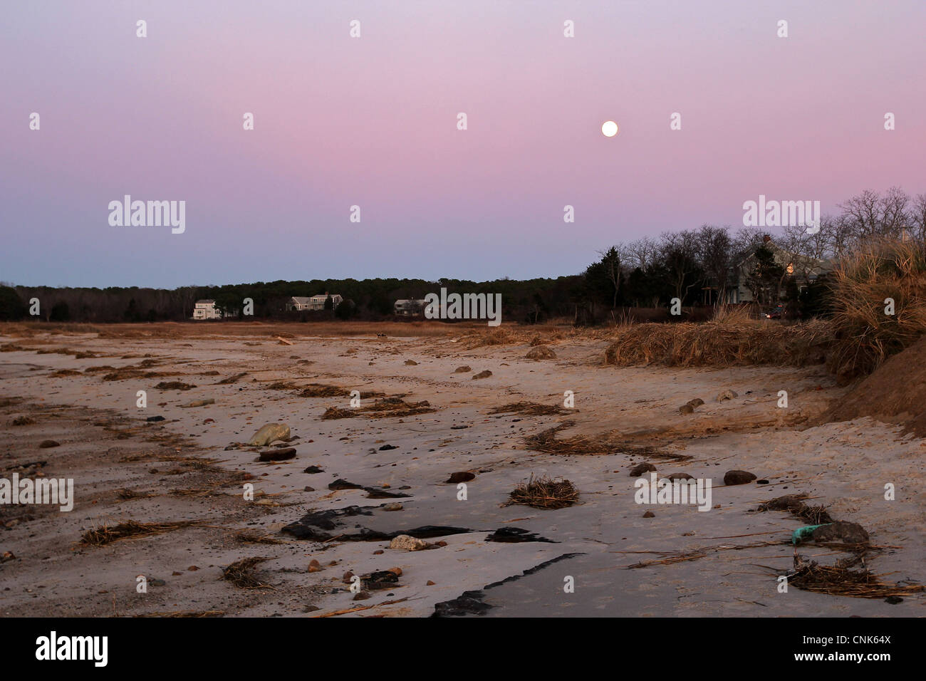 La lune brille sur une plage de Cape Cod en décembre au milieu des couleurs de coucher de soleil. Eastham, Cape Cod, Massachusetts Banque D'Images