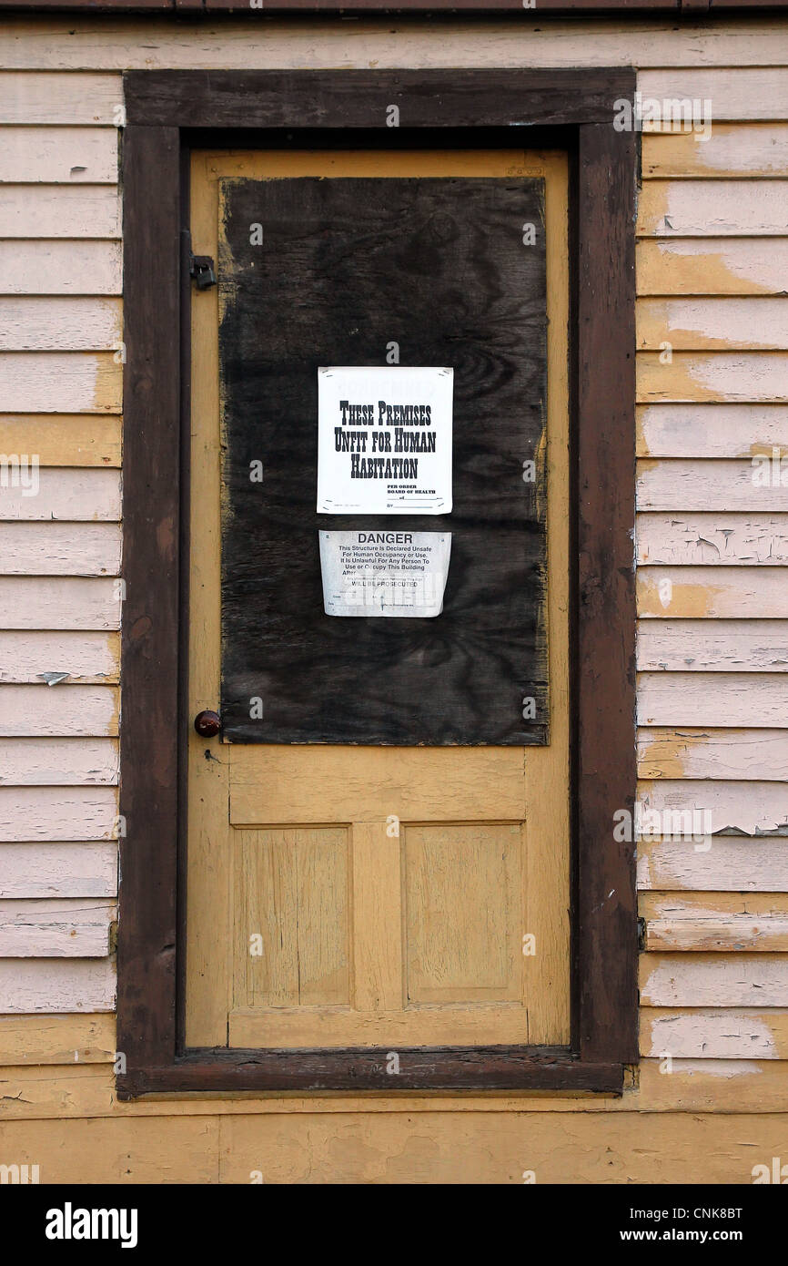 Les panneaux sur la porte d'un immeuble condamné Banque D'Images