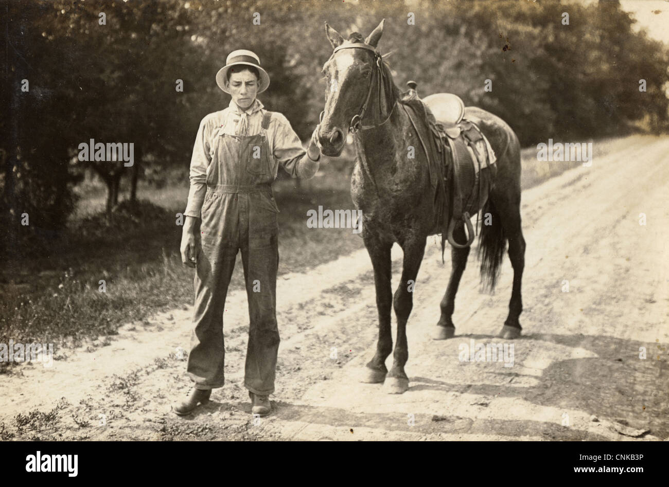 Downcast Jeune homme menant son cheval vers le bas une route de campagne Banque D'Images