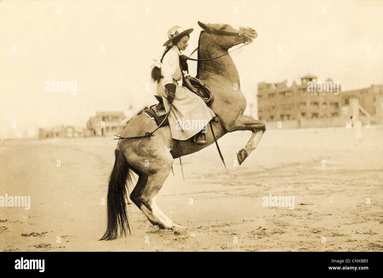 Cowgirl accroché sur un bronco sur la plage Banque D'Images