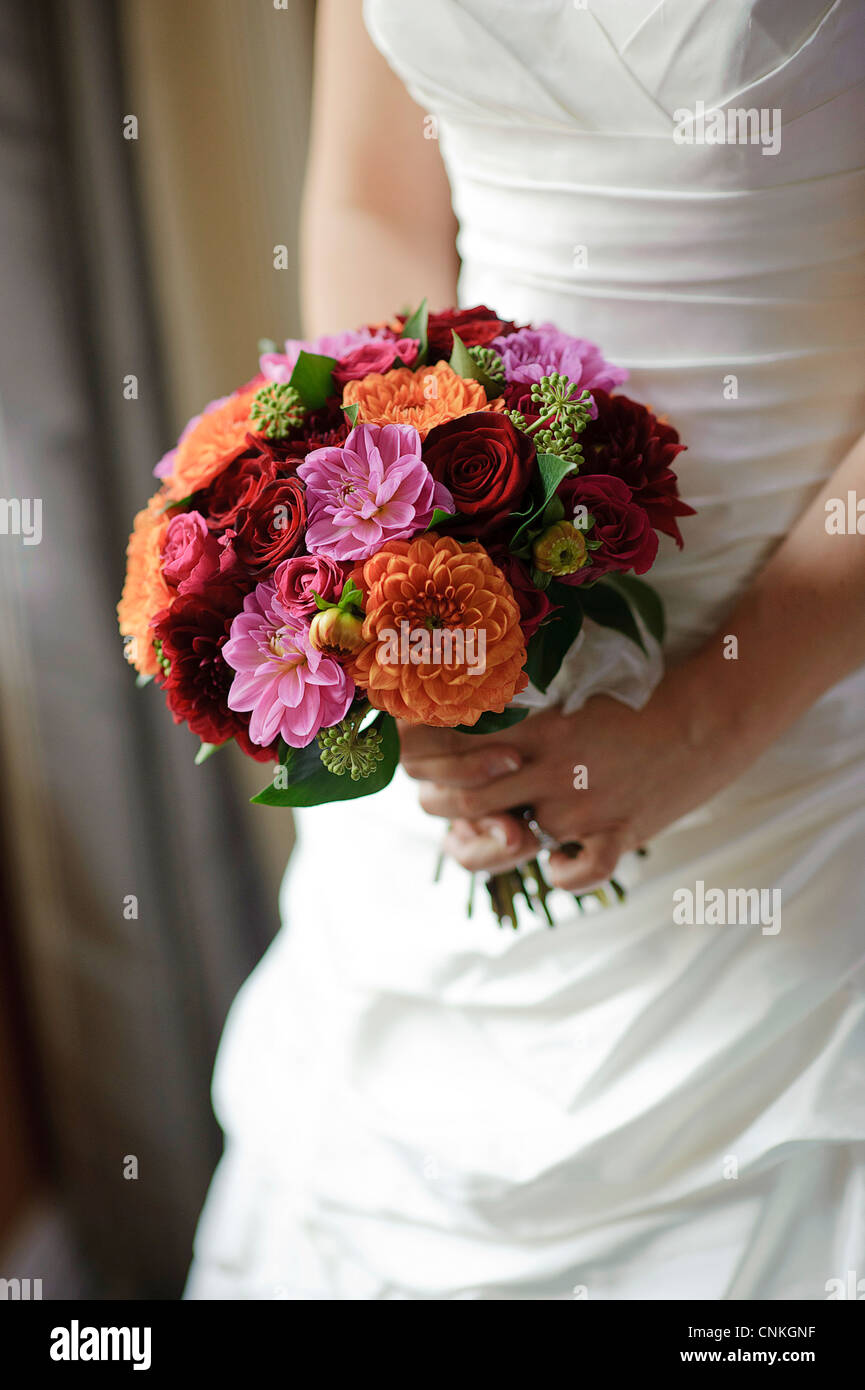 Image coupée de bride holding bouquet de fleurs de mariage à la taille Banque D'Images