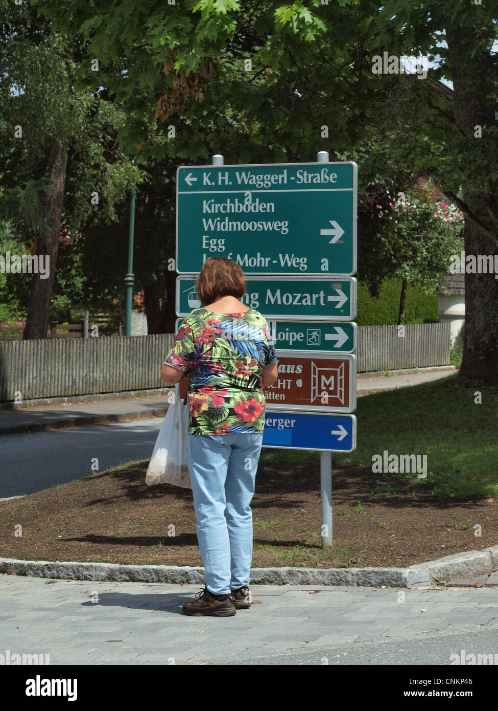 Une femelle'admirant un panneau routier à Kirchboden d accès aux sites touristiques locaux à Wargrain, près de Salzbourg en Autriche. Banque D'Images
