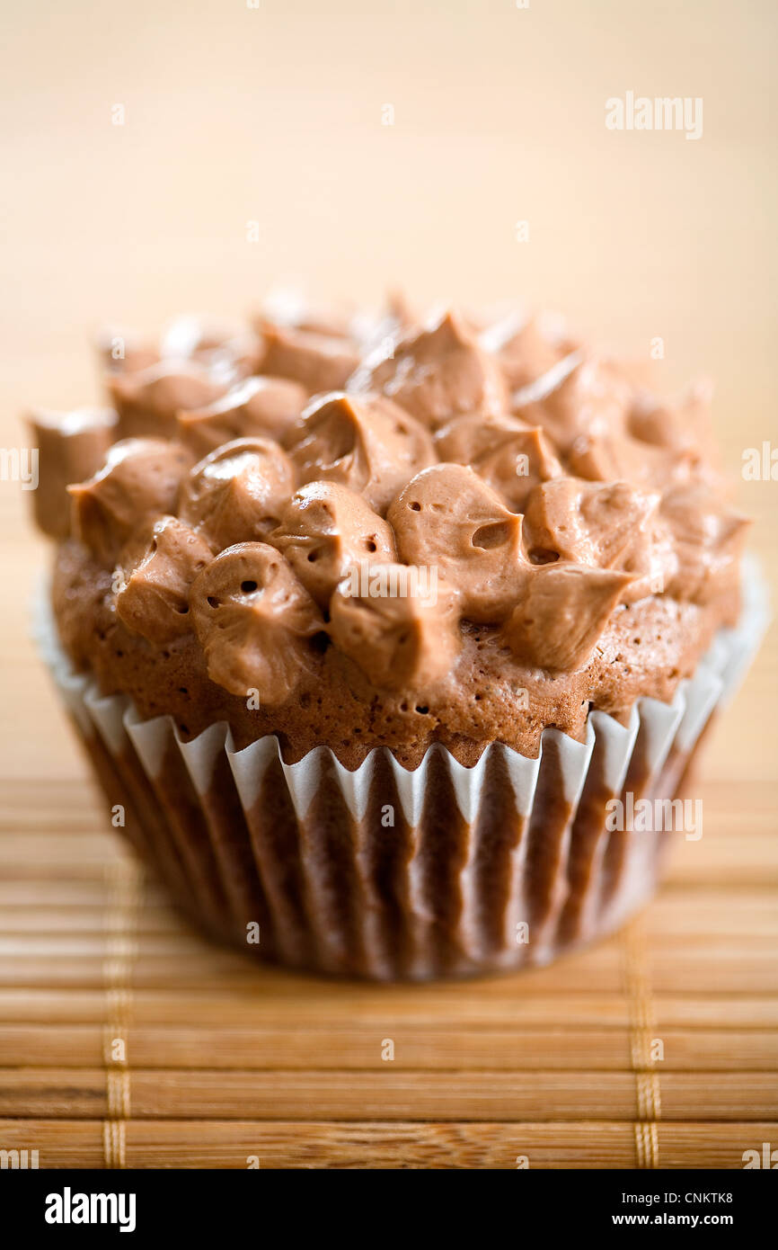 Délicieux cupcake au chocolat avec glaçage au chocolat sur le napperon de bambou -focus peu profondes Banque D'Images