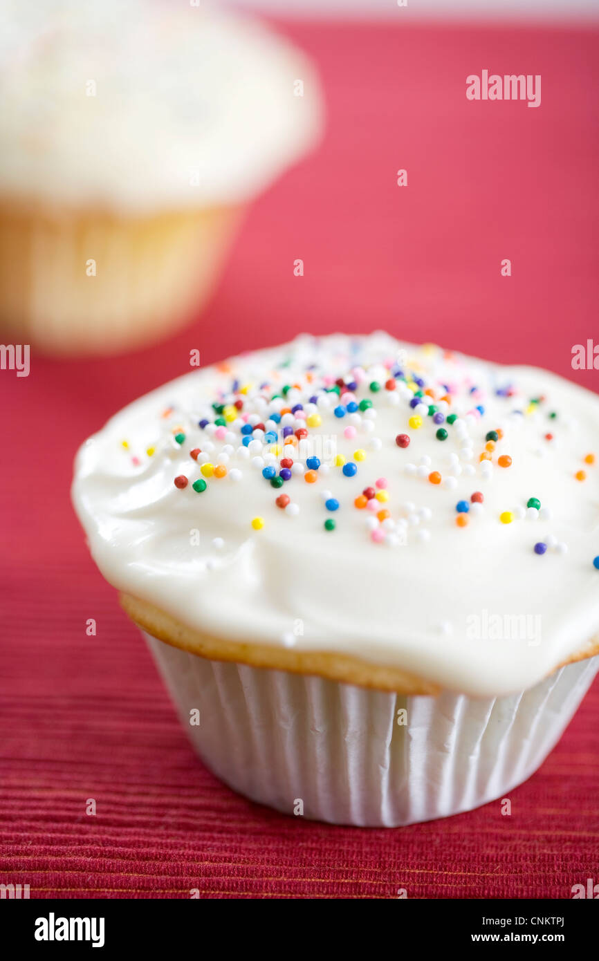 Delicieux Petit Gateau A La Vanille Avec Glacage Blanc Et Multicolore Bonbons Sur Place De Couleur Rouge Mat Focus Peu Profondes Photo Stock Alamy