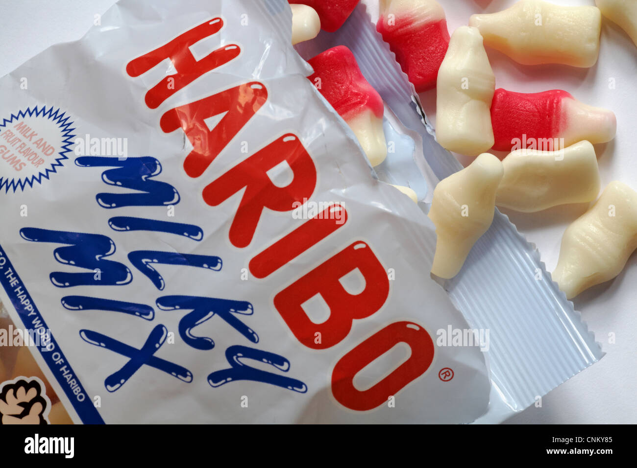 Bouteille de lait mélange laiteux Haribo sachet de bonbons ouvert avec table des matières déversées renversé - lait et la saveur de ses fruits les gencives Banque D'Images