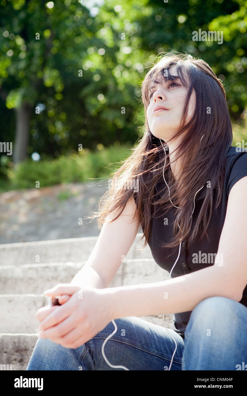 Woman listening to headphones outdoors Banque D'Images