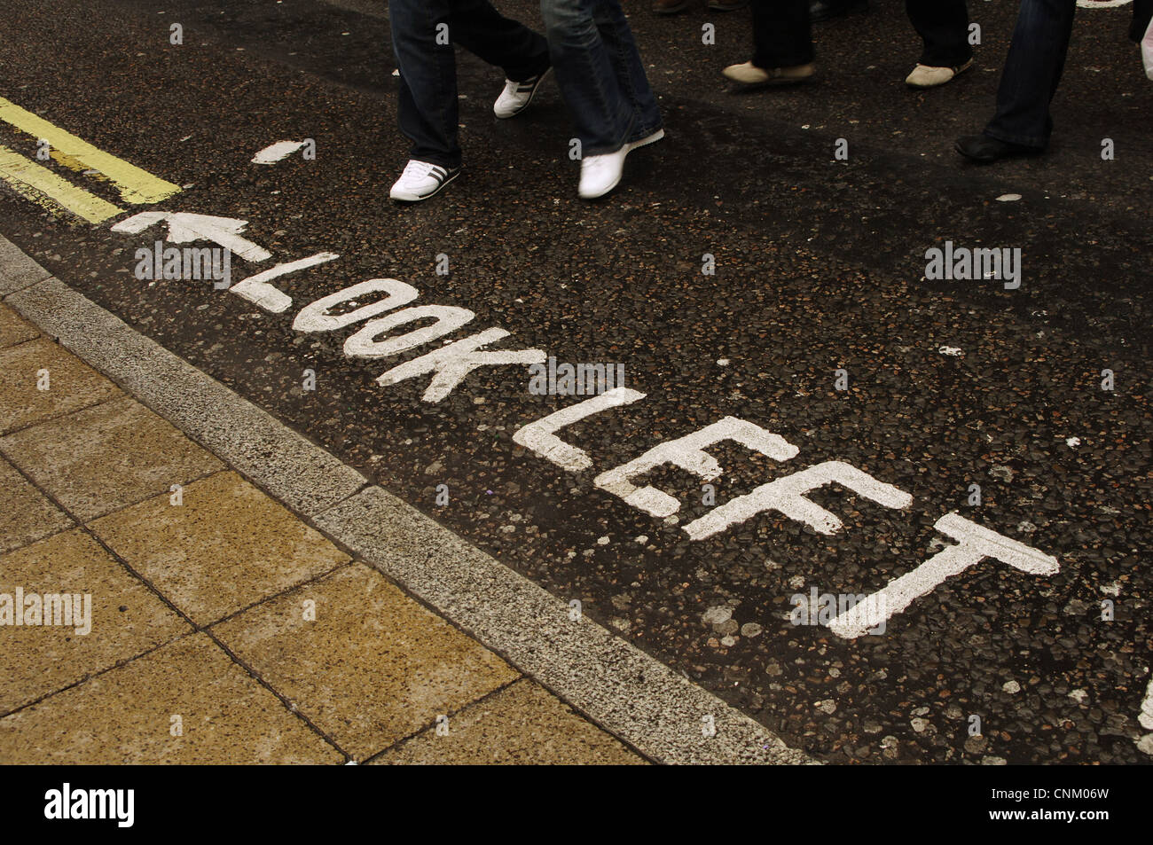 United Kingdom. Londres. Avertissement sur la route de l'obligation de regarder à gauche avant de traverser la rue. West End. Banque D'Images