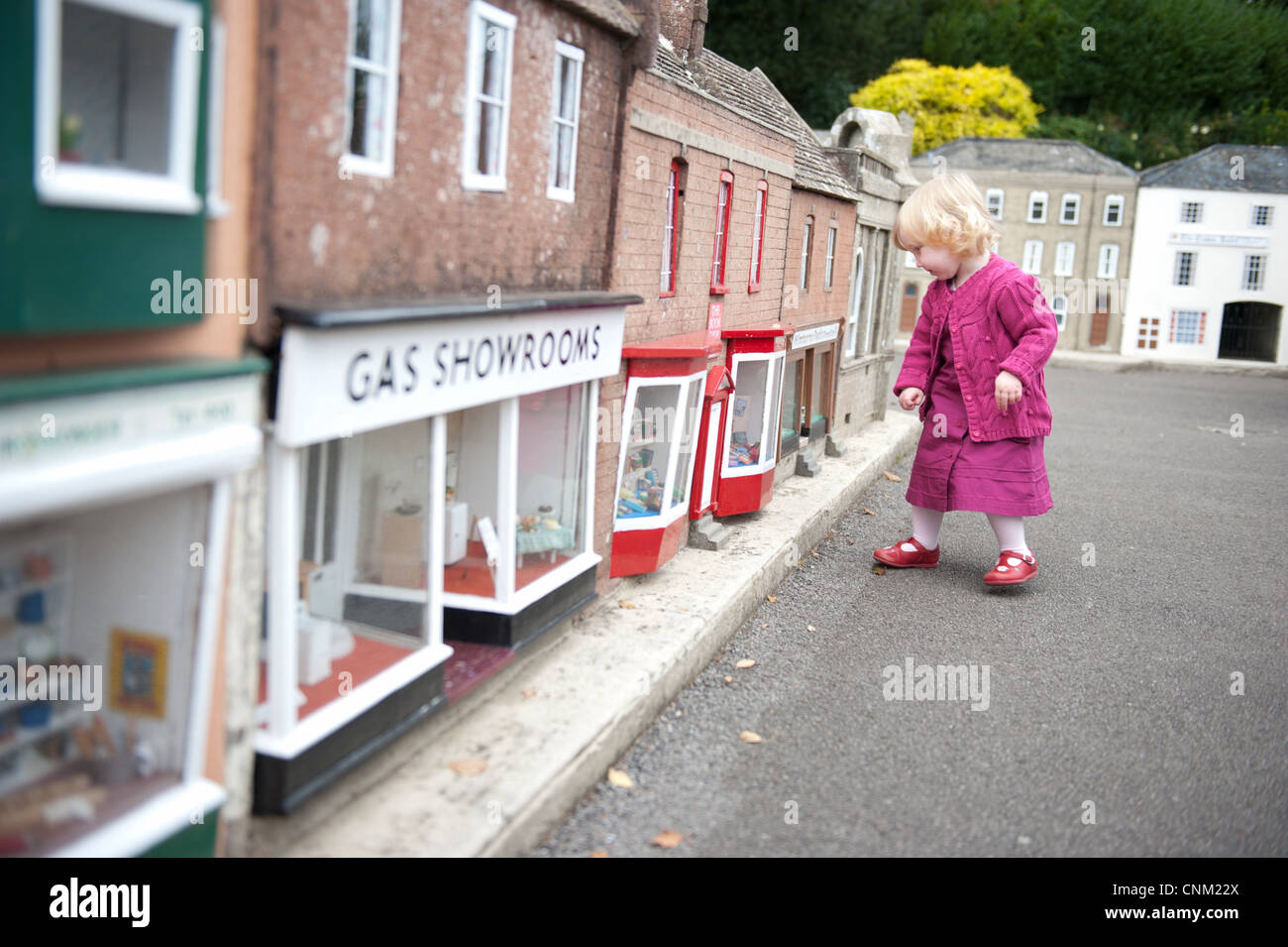 Une petite fille se promène dans les rues de Wimborne Model Village à Paris Banque D'Images