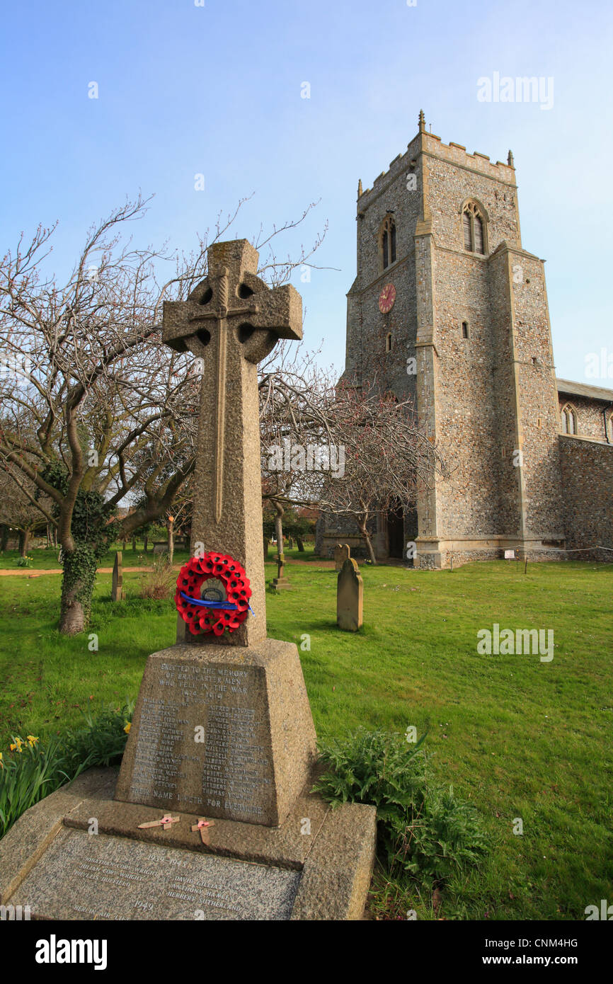 L'église de Saint Mary's à Brancaster avec une couronne de coquelicots sur un monument de guerre à la 1ère guerre mondiale. Banque D'Images
