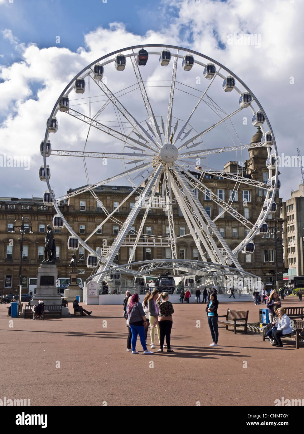 La roue de Glasgow dans George Square Glasgow Ecosse présenté par grande ville Attractions avec la statue de Robert Burns à gauche. Banque D'Images