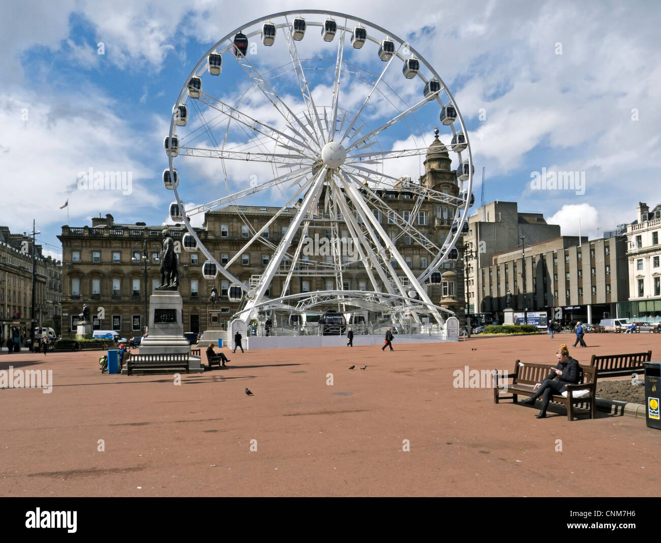 La roue de Glasgow dans George Square Glasgow Ecosse présenté par grande ville Attractions avec la statue de Robert Burns gauche.. Banque D'Images