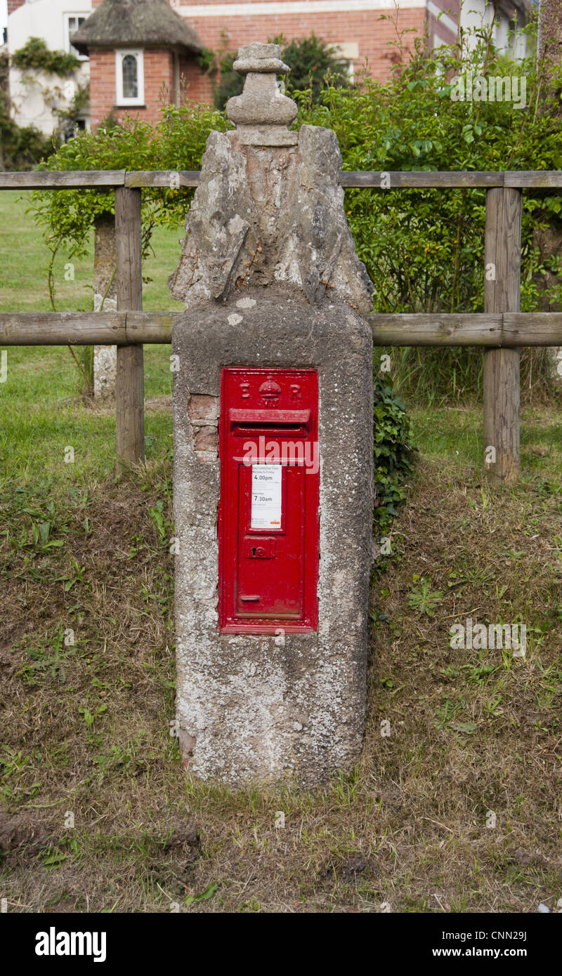 Boite aux lettres rouge monté sur poster dans village, Aylesbeare, Devon, Angleterre, mai Banque D'Images