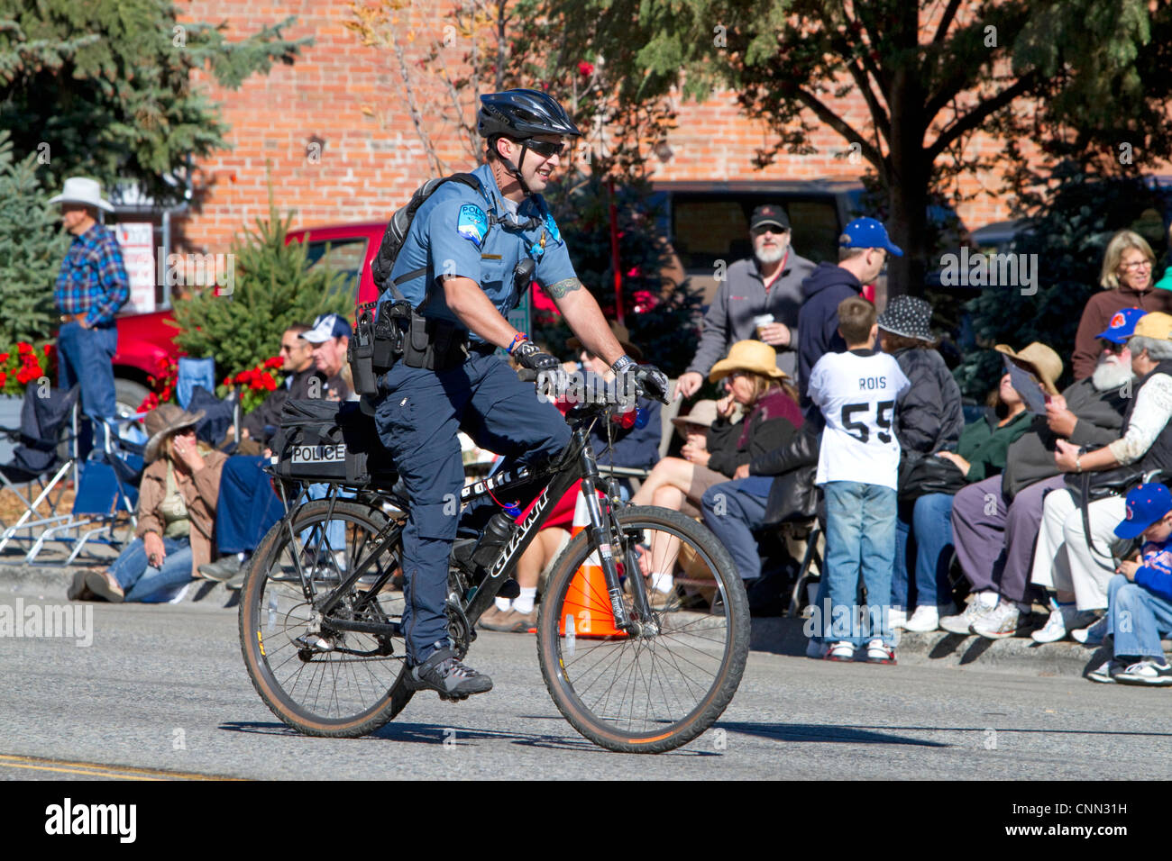 Agent de police de rouler à vélo sur le bord arrière de la Parade des moutons sur la rue Main à Ketchum, Idaho, USA. Banque D'Images