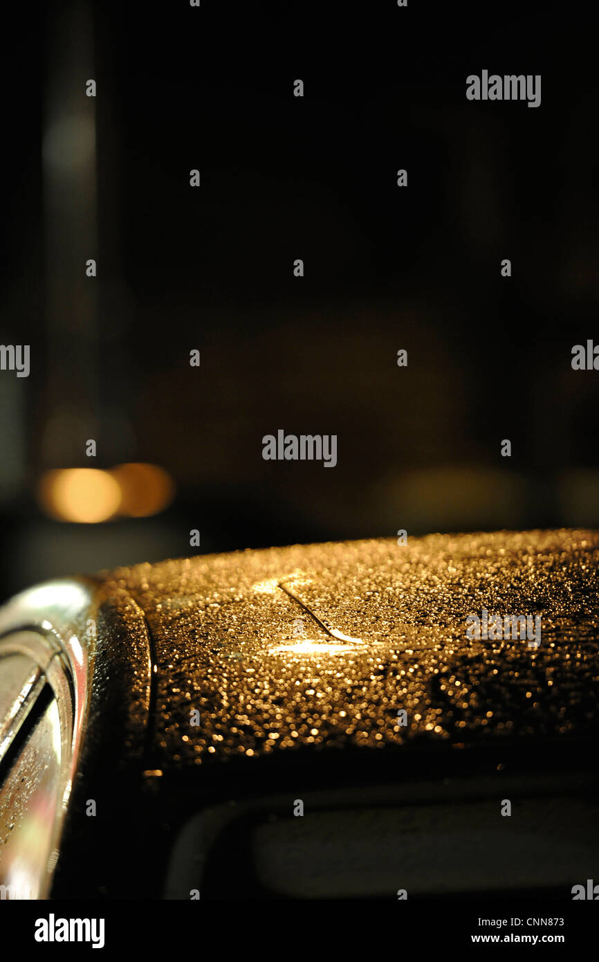 Des gouttelettes de pluie sur toit de voiture la nuit Banque D'Images