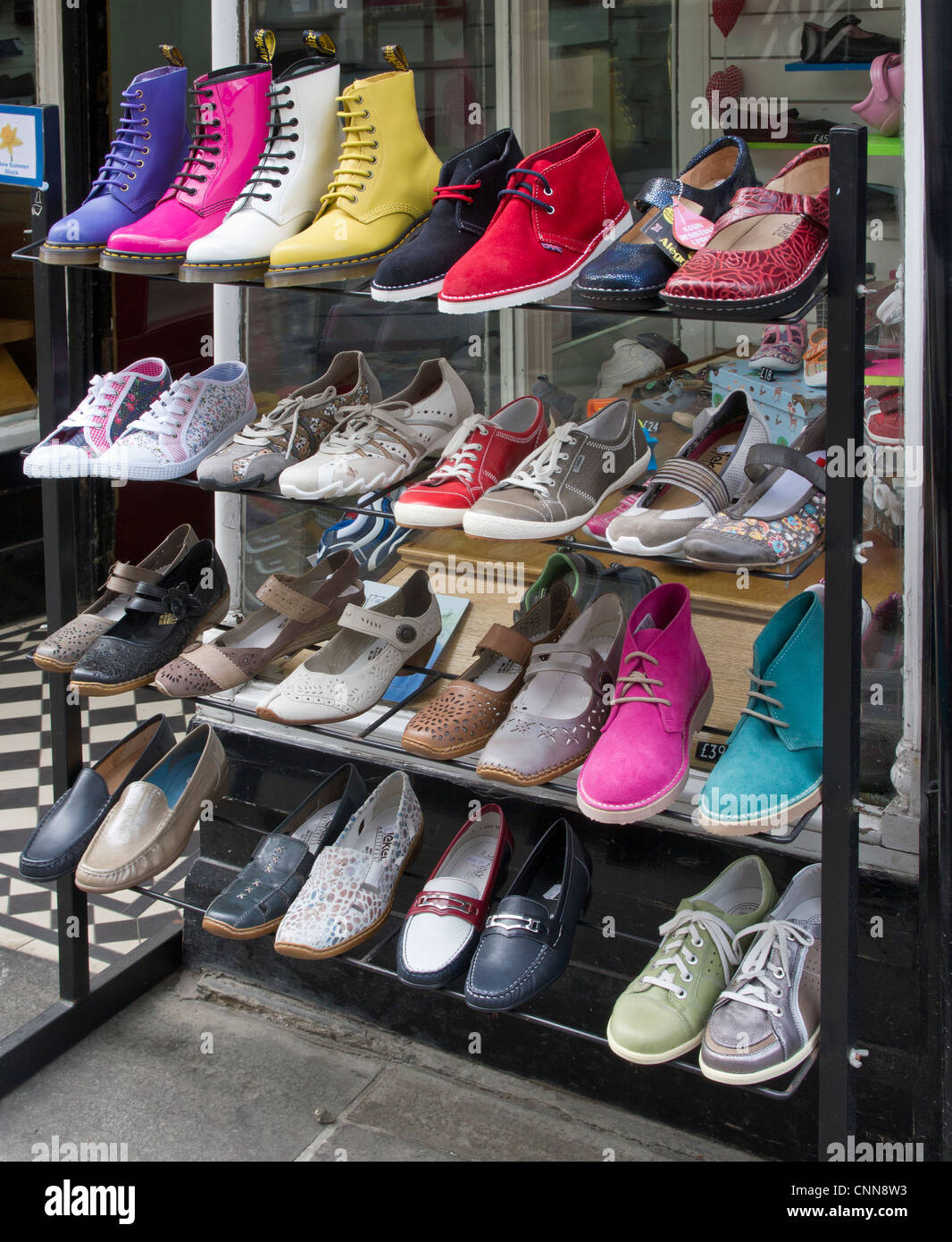 Chaussures et bottes sur présentoir en dehors d'un magasin de chaussures. Sun Street, Canterbury Kent UK Banque D'Images
