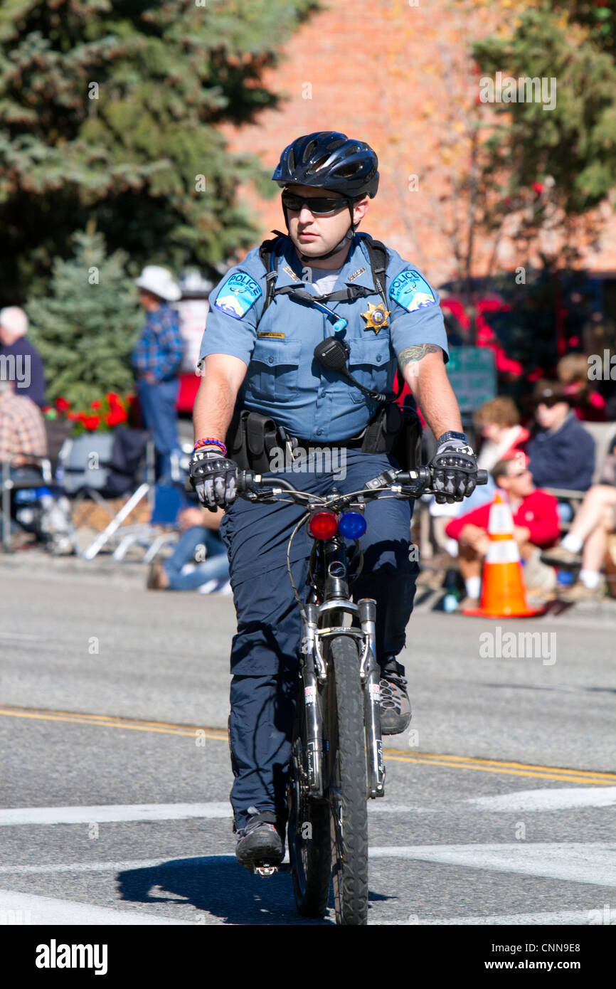 Agent de police de rouler à vélo sur le bord arrière de la Parade des moutons sur la rue Main à Ketchum, Idaho, USA. Banque D'Images