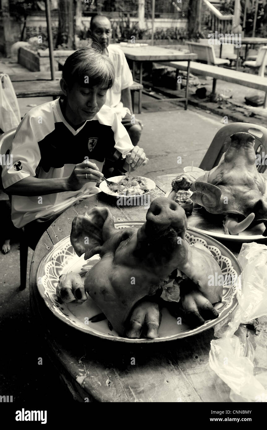 Rituel thaï de se consacrer à l'alimentation des porcs et de la tête,bouddha offrande aux dieux , pour la bonne chance et la prospérité, Bangkok, Thaïlande Banque D'Images