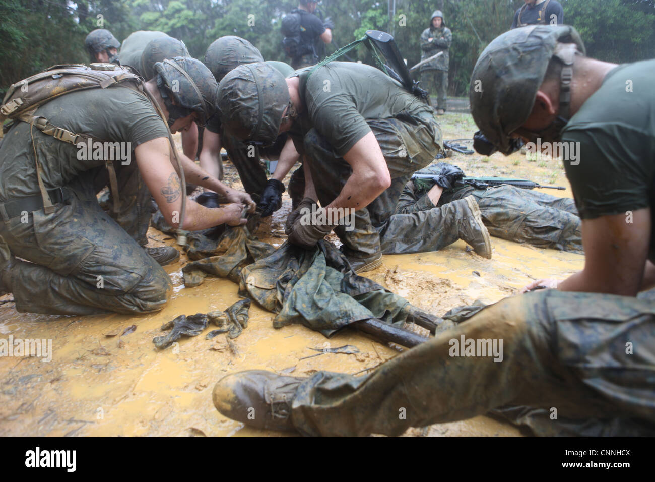 Marines du 1er peloton, compagnie B, équipe de débarquement du bataillon, 1er bataillon, 4e Marines, 31e MEU, créer un brancard improvisé lors de leur cours Jungle Endurance à Okinawa. Cet exercice teste leurs compétences dans le transport médical sur le terrain et les techniques de survie dans la guerre de jungle. Banque D'Images