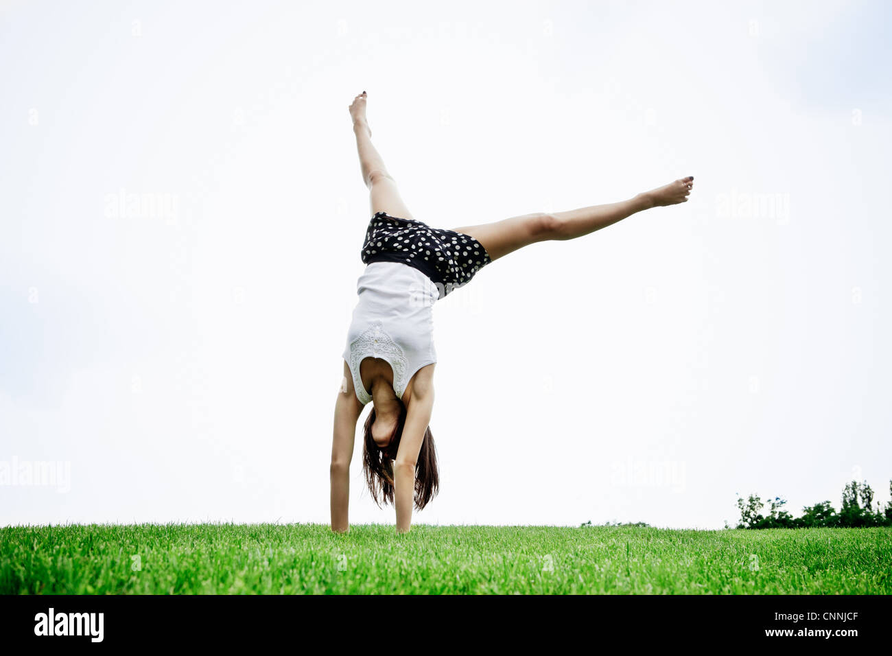 Woman doing cartwheel outdoors Banque D'Images