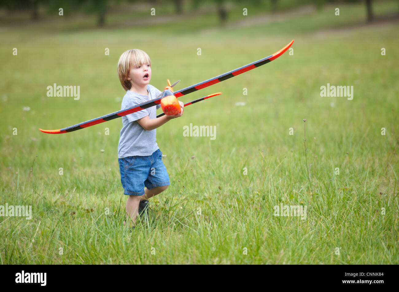 Boy Playing with toy airplane outdoors Banque D'Images